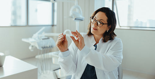 Dentist examining dental aligner in a modern clinic portrait