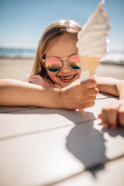 Cute girl having ice cream at the beach