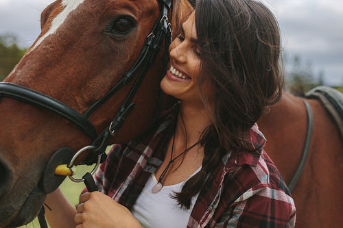 Smiling cowgirl with her horse 