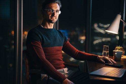 Nighttime work: Dedicated businessman sitting at desk with laptop