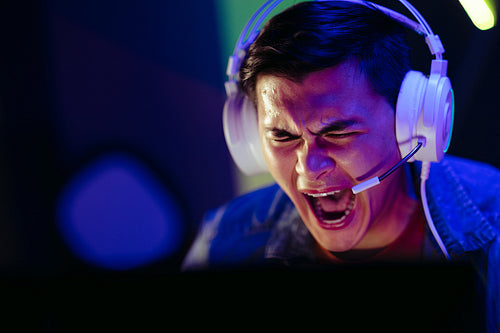 Gamer letting out an intense shout as he approaches victory in a video game