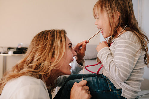 Pediatrician checking throat of a girl