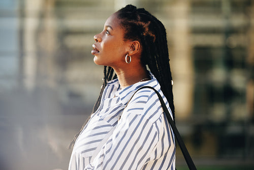 Sideview of a young businesswoman standing outdoors in the city