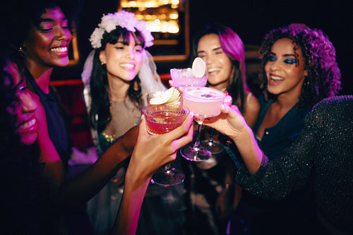Group of girlfriends celebrating with cocktails at a festive party