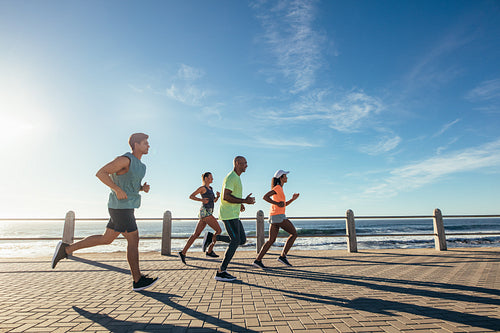 Group of athletes running on ocean front