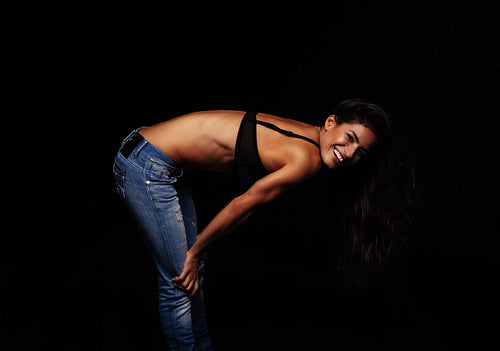 Happy young woman posing in jeans and bra