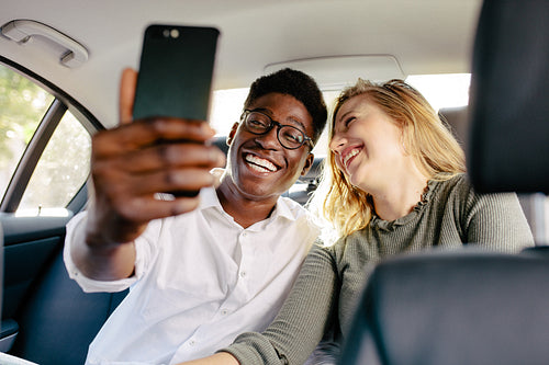 Couple traveling by a car taking selfie