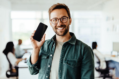Business man recommending a mobile phone in an office