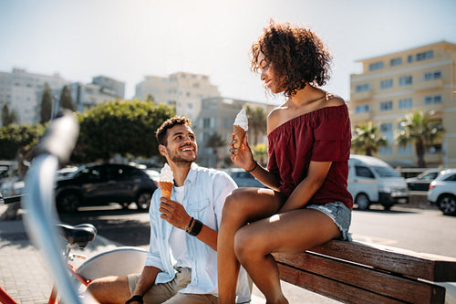 Couple enjoying ice cream sitting outdoors