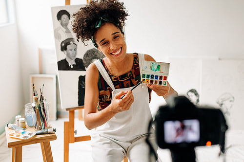 Freelancer recording a painting tutorial in her art studio
