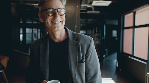 Successful businessman having a coffee in office