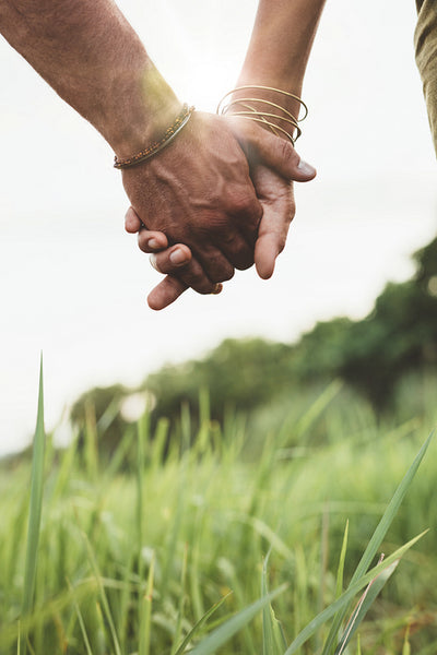 Beautiful couple holding hands on the field