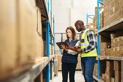 Warehouse workers using a warehouse management system on a digital tablet