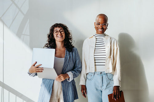Young businesswomen in modern office smiling and looking at camera
