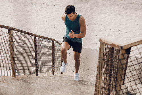 Runner exercising on the staircase on beach