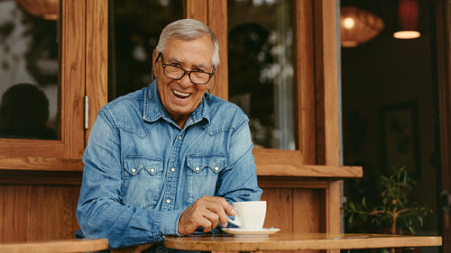 Smiling senior man relaxing at cafe