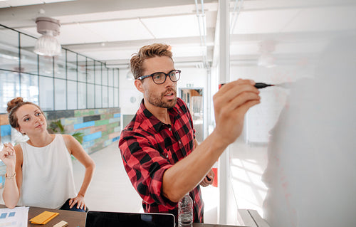 Casual business giving a presentation to coworkers