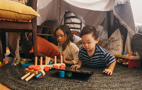 Two young siblings playing together at home