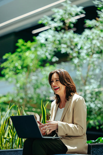 Contemporary workplace scene with a female CEO using a laptop in a green office setting