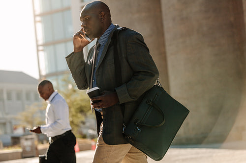 People busy using mobile phone while walking on street to office