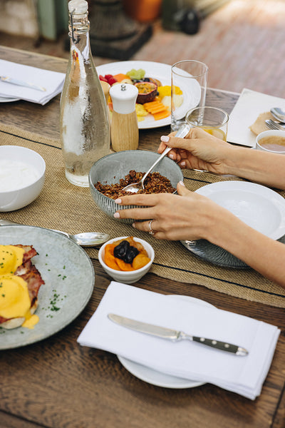Anonymous woman having breakfast at a table