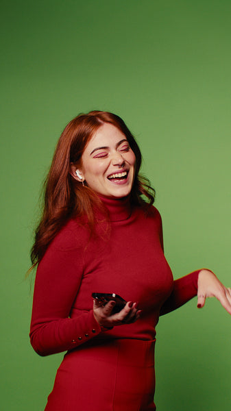 Happy woman in red using phone on green screen background