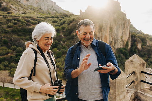 Mature couple having a video call while hiking outdoors