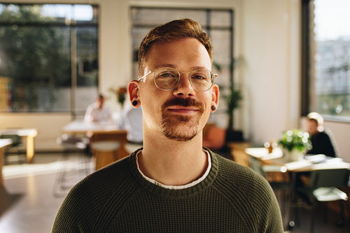 Happy entrepreneur standing in office