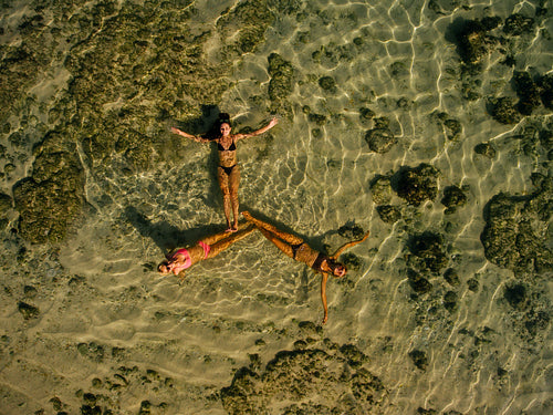 Three young women lying in sea water