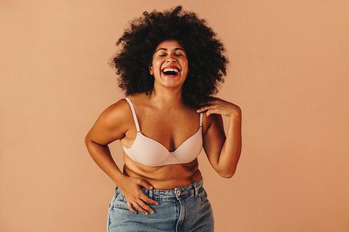 Beautiful woman with Afro hair laughing happily in a studio