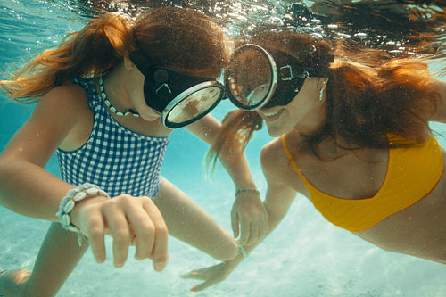 Island getaway: Family enjoying fun underwater moments in swimsuits
