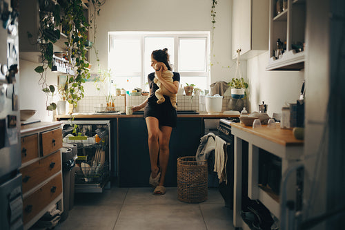 Mother holding baby in cozy kitchen
