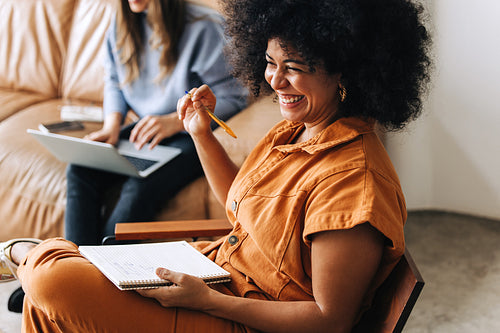 Black businesswoman smiling cheerfully in an office lobby