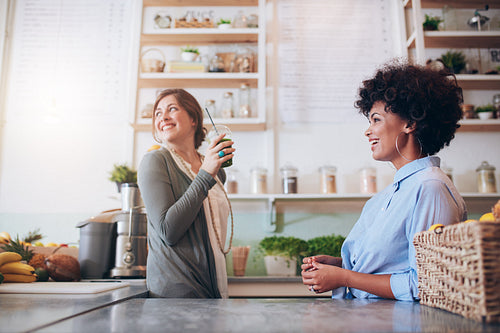 Young women working at fruit juice bar