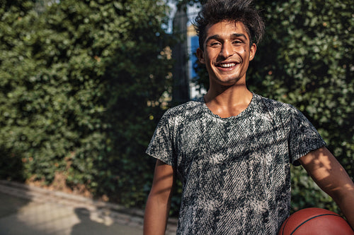 Happy teenage streetball player on court