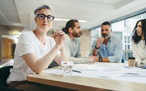 Mature businesswoman attending a meeting with her team