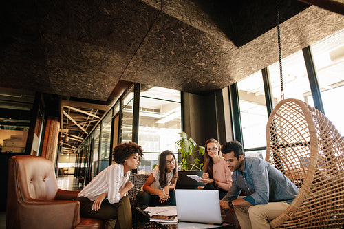 Creative business team using laptop during meeting