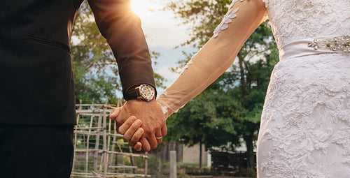 Couple holding hands on their wedding day