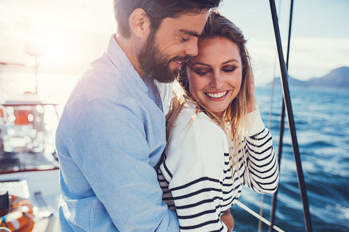 Romantic young couple standing on sailboat