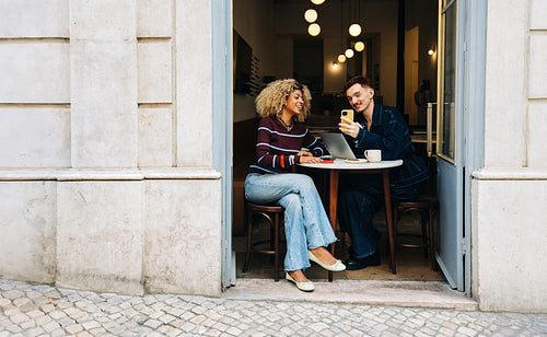 Friends in a cafe working on a laptop together