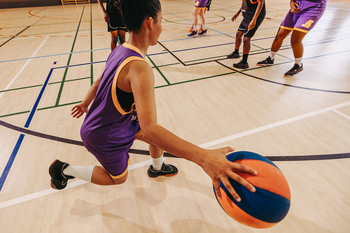 Basketball player dribbling ball during a game on indoor court