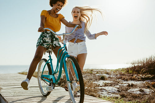 Cheerful girls having fun with a cycle