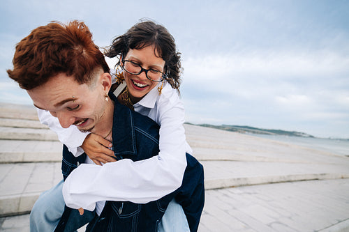 Playful happy couple sharing a piggyback moment