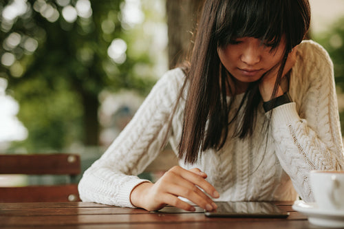 Young woman using digital tablet at coffeeshop