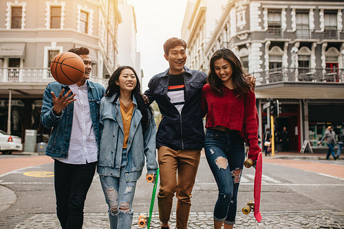 Four friends walking on city street