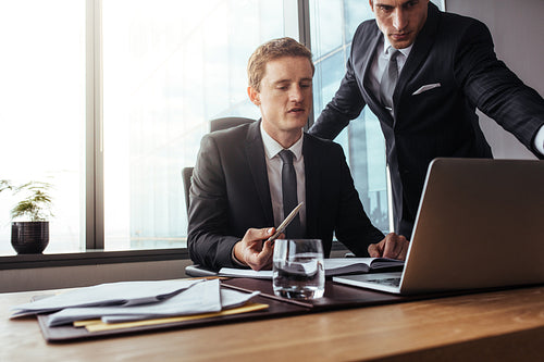 Corporate professionals working together on laptop