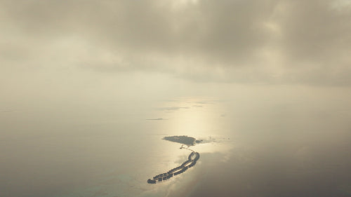 Aerial view captures a luxurious remote island resort with overwater bungalows