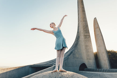 Female ballet dancer practicing dance moves on a rock