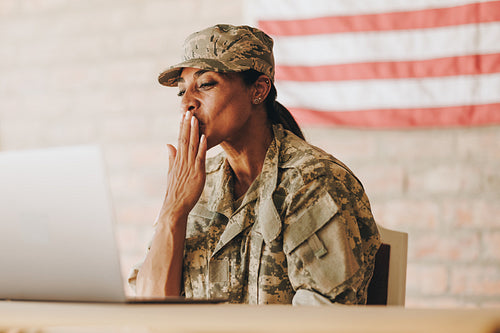 Female soldier video calling her family on a laptop