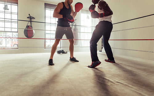Boxer training with his coach in a boxing ring